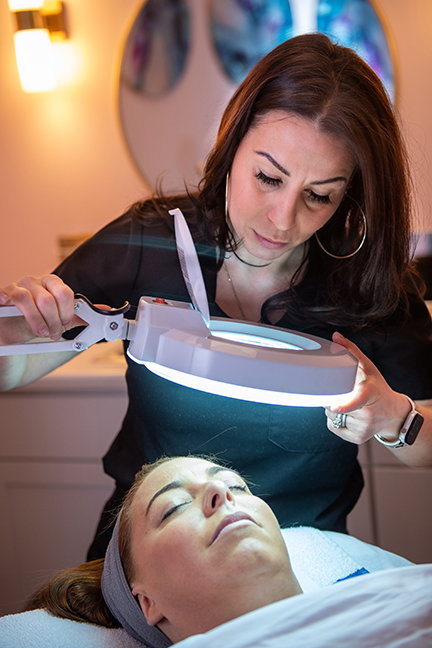 Skin Studio in Ithaca facial treatment using a magnifying light